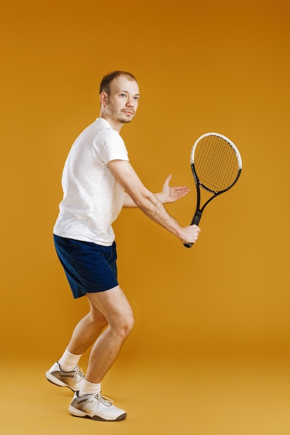 Il giovane tennista gioca a tennis su un giallo