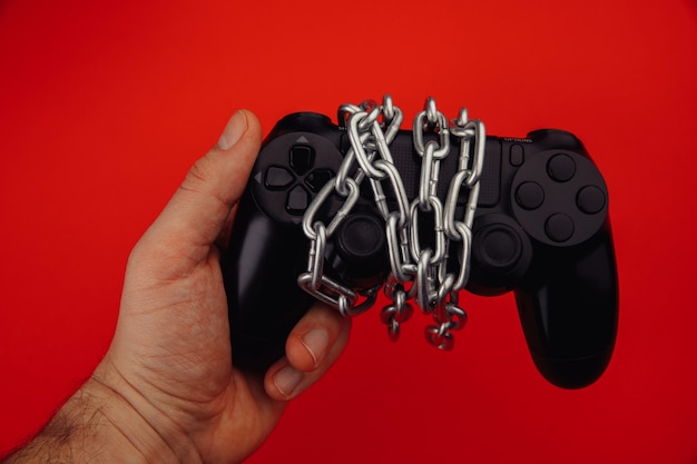 Il giovane tiene un controller di gioco è legato.