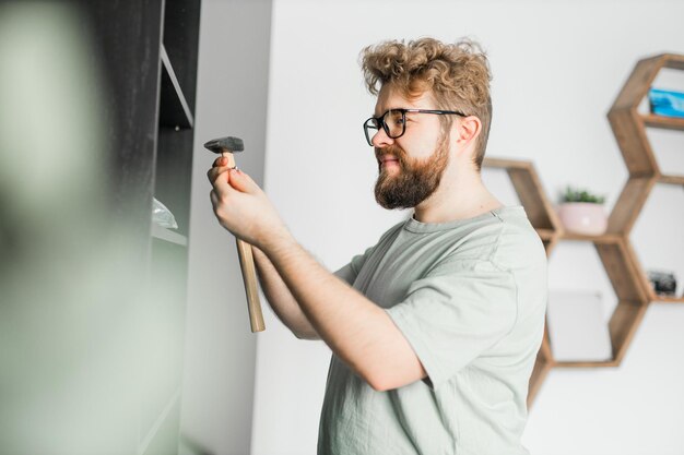 Il giovane uomo attraente assembla il handwerker di mobili e il concetto di oggetti interni