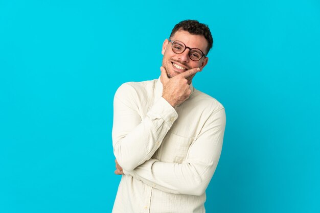 Il giovane uomo bello caucasico ha isolato felice e sorridente