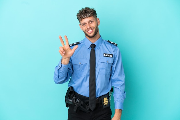 Il giovane uomo biondo della polizia ha isolato il bianco su fondo blu felice e conta tre con le dita