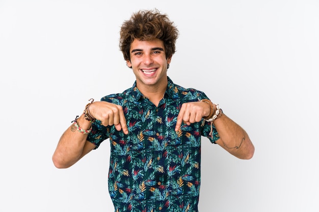 Il giovane uomo caucasico che indossa una maglietta del fiore indica giù con le dita