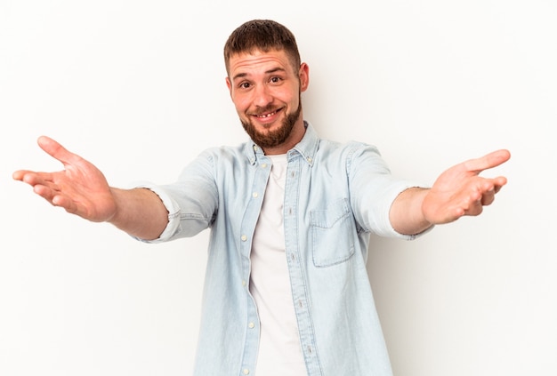 Il giovane uomo caucasico con diastema isolato su sfondo bianco si sente sicuro di dare un abbraccio alla telecamera.