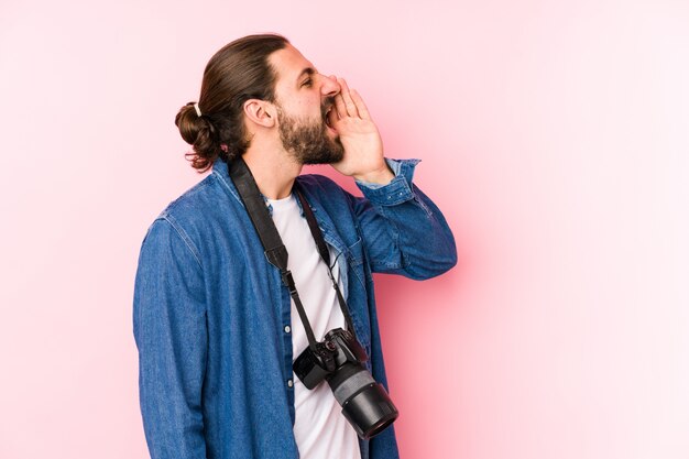 Il giovane uomo caucasico del fotografo che grida e che tiene la palma vicino ha aperto la bocca.