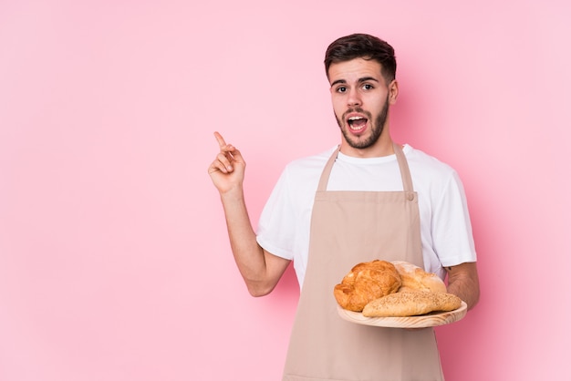 Il giovane uomo caucasico del panettiere ha isolato indicare il lato