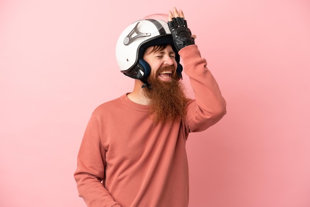Il giovane uomo caucasico rossastro con un casco da motociclista isolato su sfondo rosa ha realizzato qualcosa e intendeva la soluzione