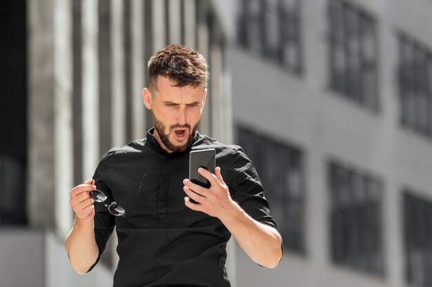 Il giovane uomo con la barba ha vinto il premio sul suo smartphone