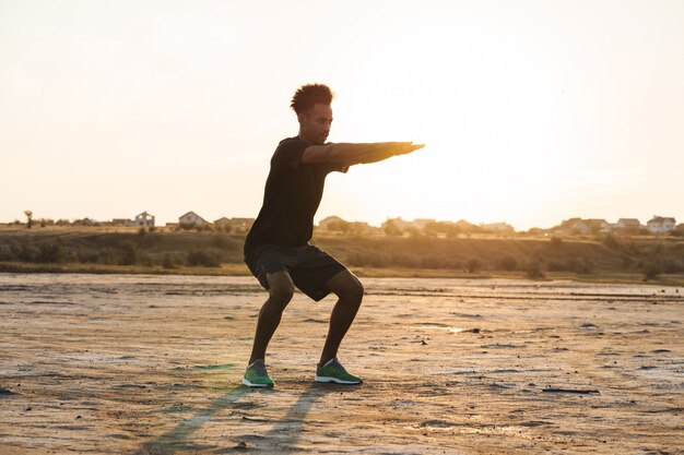 Il giovane uomo di sport fa esercizi di fitness all'aperto