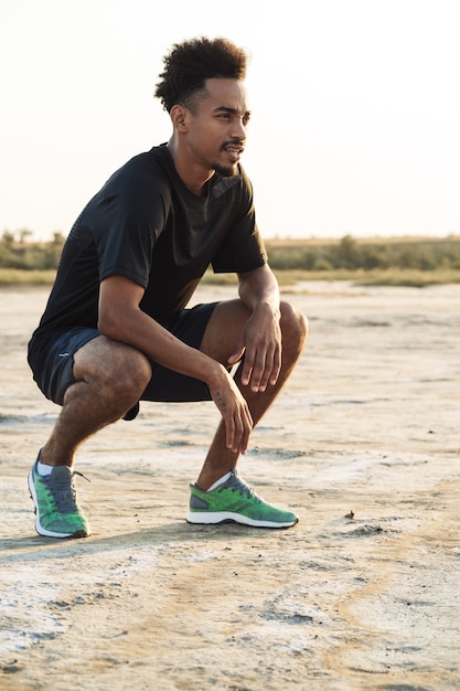 Il giovane uomo di sport fa esercizi di fitness all'aperto