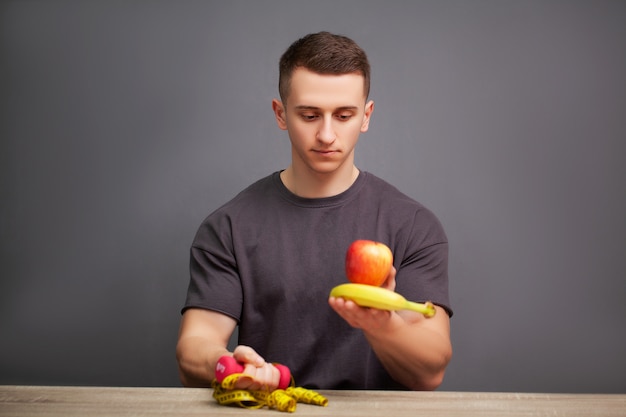 Il giovane uomo sportivo fisico tiene un pasto ricco di proteine per una buona alimentazione