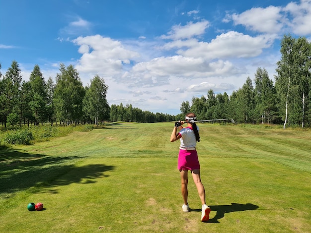 Il golfista femminile oscilla la mazza da golf sul campo da golf