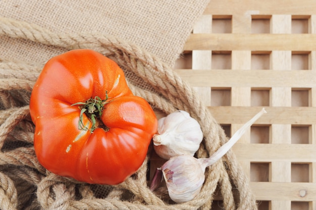 Il grande pomodoro rosso e aglio sul beige