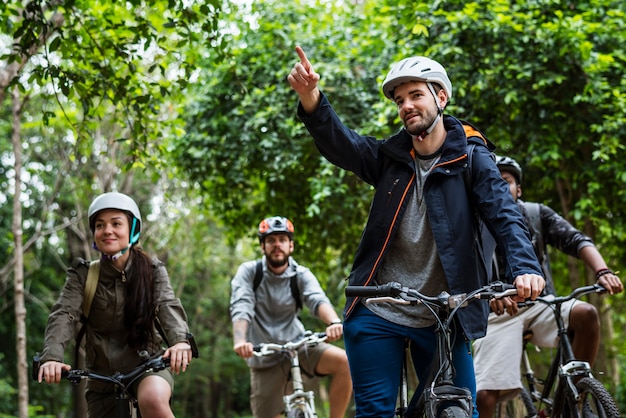 Il gruppo di amici guida insieme la mountain bike nella foresta