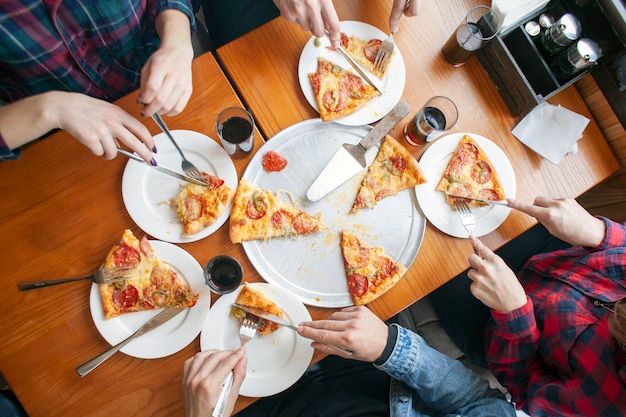 Il gruppo di amici mangia la pizza italiana