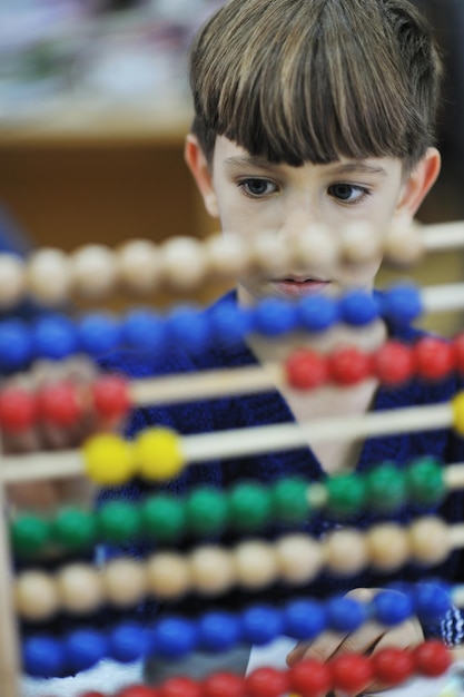 il gruppo di bambini felici si diverte e gioca al concetto di educazione prescolare al coperto dell'asilo con l'insegnante