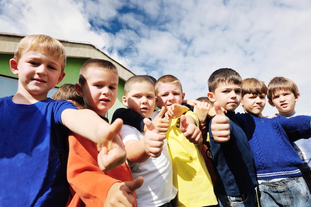 il gruppo di bambini felici si diverte e gioca al concetto di educazione prescolare all'aperto dell'asilo con l'insegnante