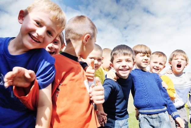 il gruppo di bambini felici si diverte e gioca al concetto di educazione prescolare all'aperto dell'asilo con l'insegnante