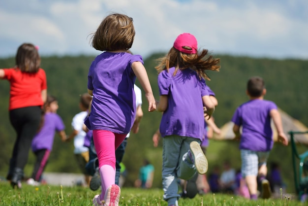 il gruppo di bambini felici si diverte nel parco naturale all'aperto