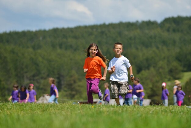 il gruppo di bambini felici si diverte nel parco naturale all'aperto