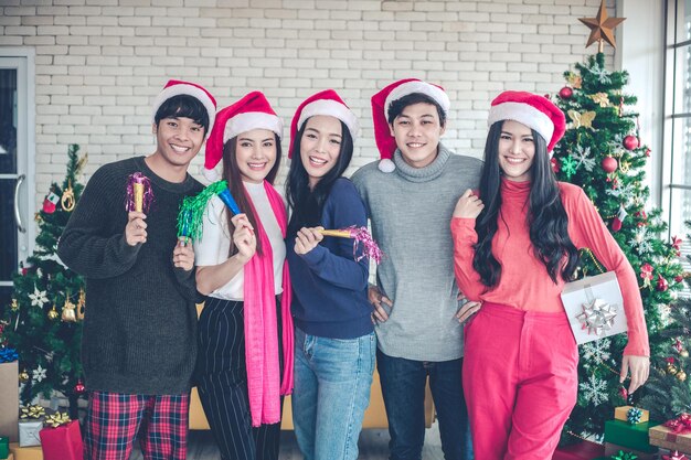 Il gruppo di giovani asiatici in festa festeggia il Natale e il Capodanno in casa con gioia e divertimento.