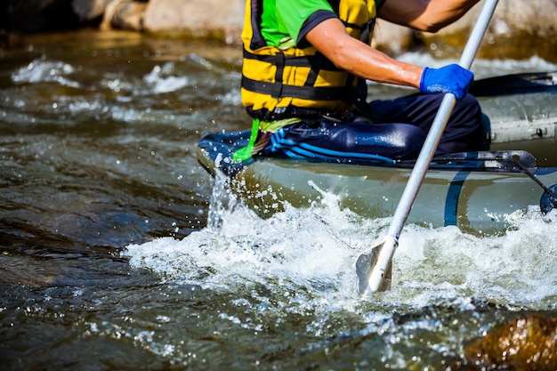 Il gruppo di giovani sta trasportando rafting in un fiume. Avvicinamento