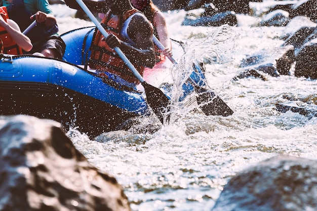 Il gruppo di giovani sta trasportando rafting in un fiume. Avvicinamento