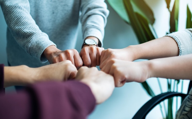 Il gruppo di lavoro del team aziendale unisce le mani insieme al potere e al concetto di successo