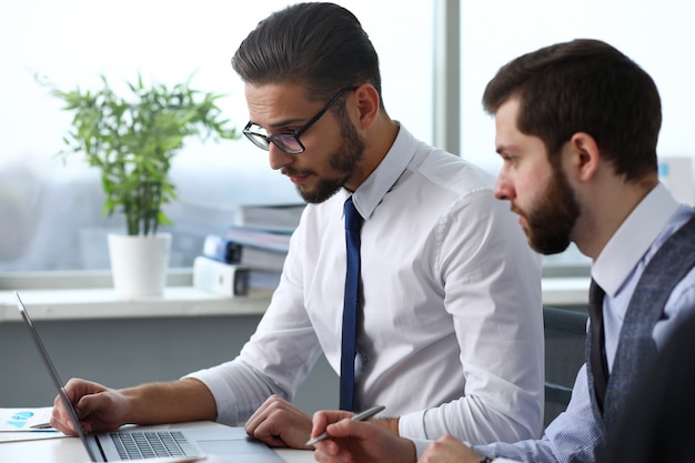 Il gruppo di persone in ufficio usa il ritratto del pc del computer portatile