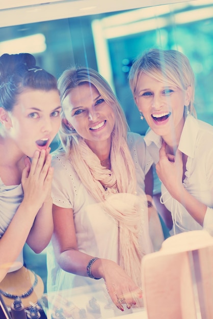 il gruppo di ragazze felici si diverte mentre fa shopping in gioielleria