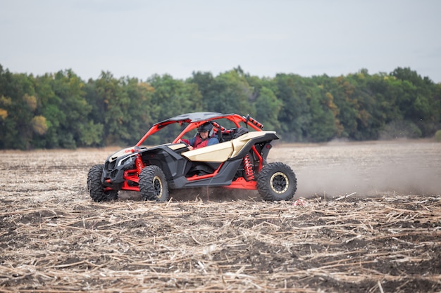 Il guidatore al volante della quad bike sta guidando intorno al campo