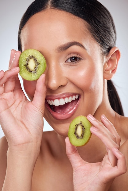 Il kiwi è un booster nutriente per la tua routine di cura della pelle Ritratto in studio di una bella giovane donna che posa con kiwi su uno sfondo grigio