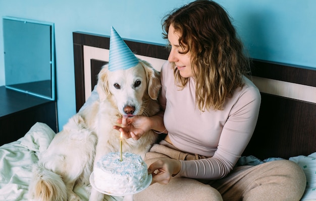 Il labrador golden retriever cane festeggia il compleanno in berretto e con torta