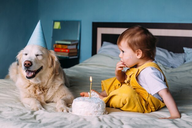 Il labrador golden retriever insieme a un bambino carino festeggia il compleanno