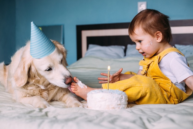Il labrador golden retriever insieme a un bambino carino festeggia il compleanno