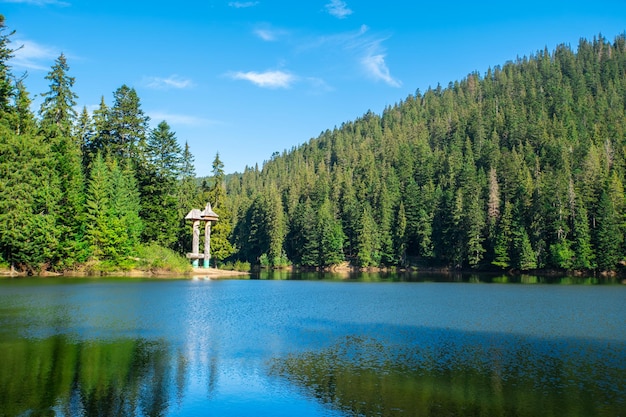 Il lago è circondato da foreste di conifere e montagne in una limpida giornata estiva