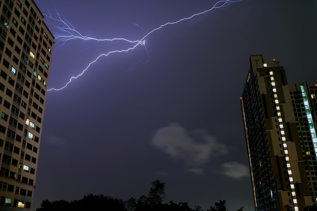 Il lampo reale che infiamma nel cielo notturno sopra le alte costruzioni di Bangkok, Tailandia