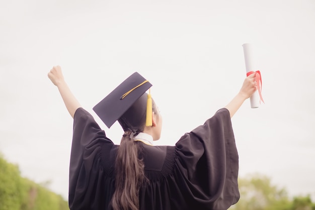 Il laureato ha alzato la mano e ha festeggiato con un certificato in mano