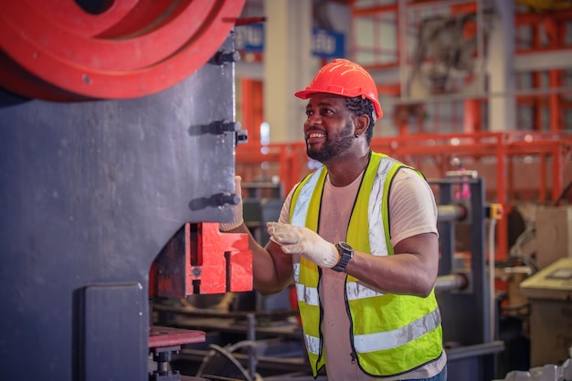 Il lavoratore americano che lavora in fabbrica L'uomo nero afroamericano è industriale di una fabbrica di macchine per il controllo dell'operatore