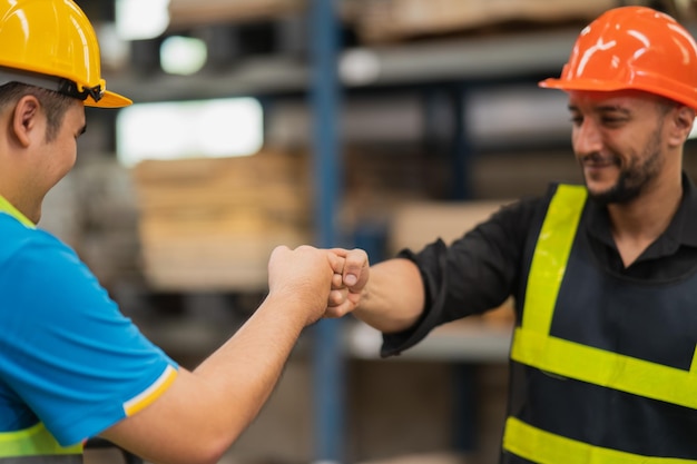 Il lavoratore o l'ingegnere del magazzino industriale nella stretta di mano della suite di sicurezza celebrano il successo o l'impegno di trattativa Catena di fornitura logistica e attività di magazzino Unità di lavoro di squadra sotto il concetto di vista