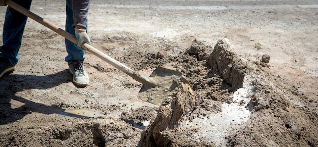 Il lavoratore prepara il calcestruzzo con la pala in cantiere