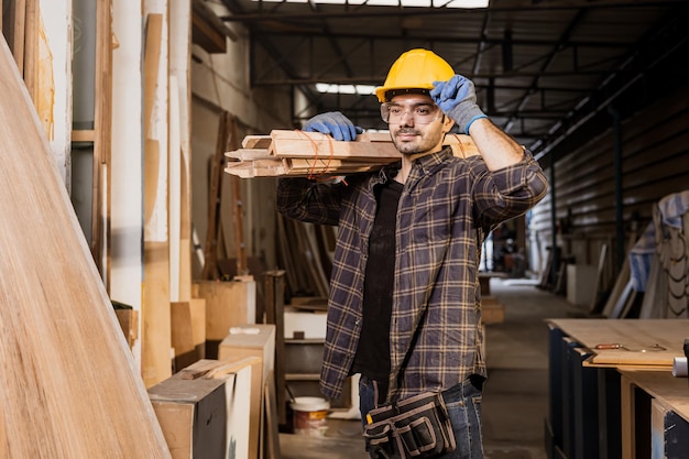 Il lavoratore sicuro indiano ispanico del ritratto lavora nel cantiere con l'operaio di fabbrica della mobilia di legno del palo di legno