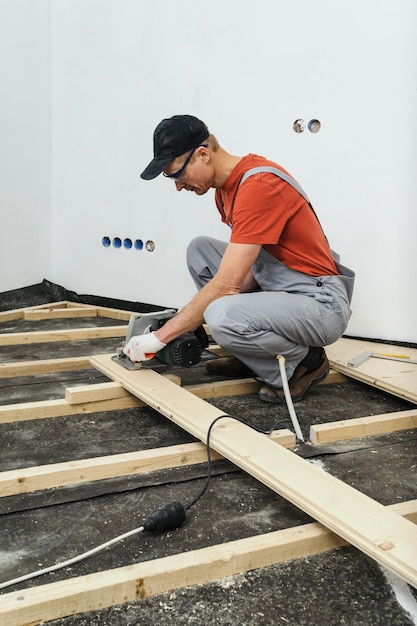 Il lavoratore taglia assi di legno.