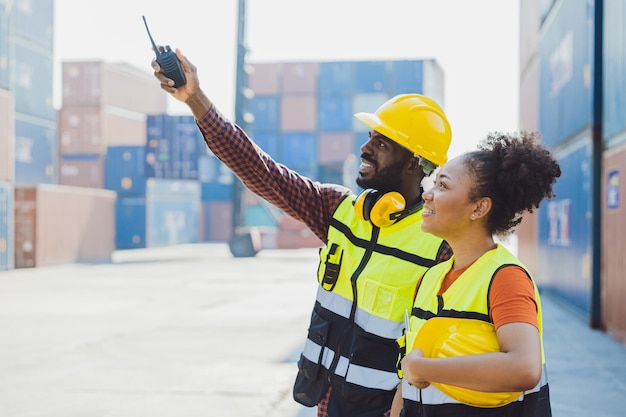 Il lavoro di squadra della gente del lavoratore africano lavora felicemente insieme nell'industria del trasporto merci portuale che carica l'iarda del contenitore