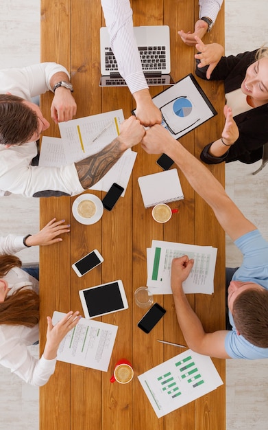 Il lavoro di squadra e il concetto di teambuilding in ufficio, le persone sbattono i pugni