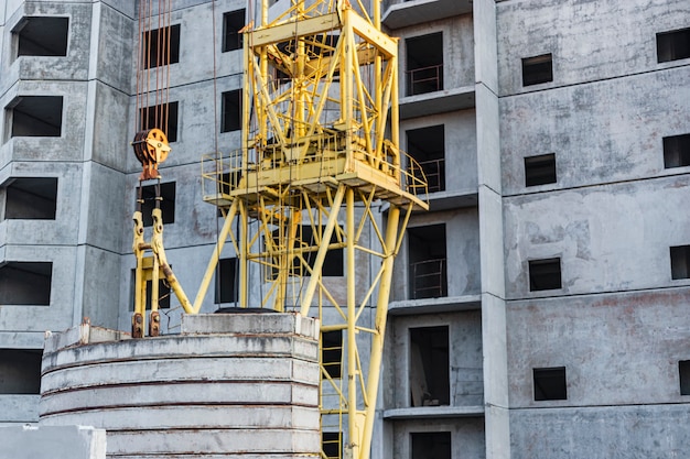 Il lavoro di una gru a torre durante la costruzione di una casa a pannelli in cemento armato