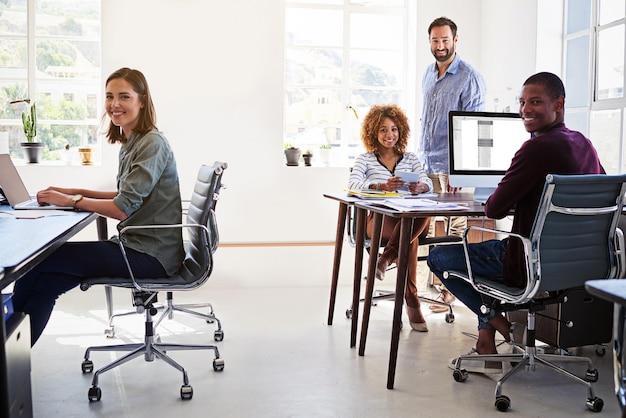 Il layout dell'ufficio migliora la produttività Ritratto di un team di colleghi che lavorano in un ufficio open space