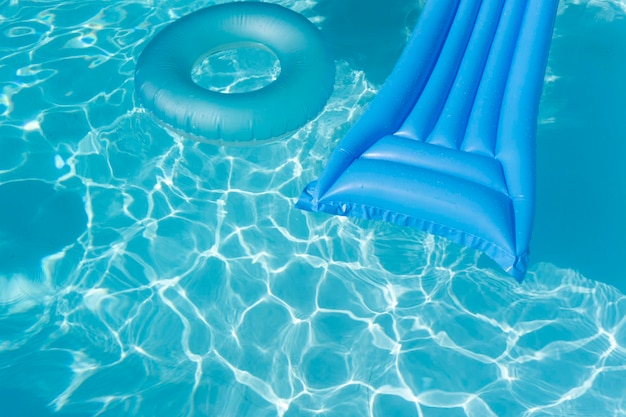 Il lettino da piscina estivo blu brillante galleggia su una piscina increspata