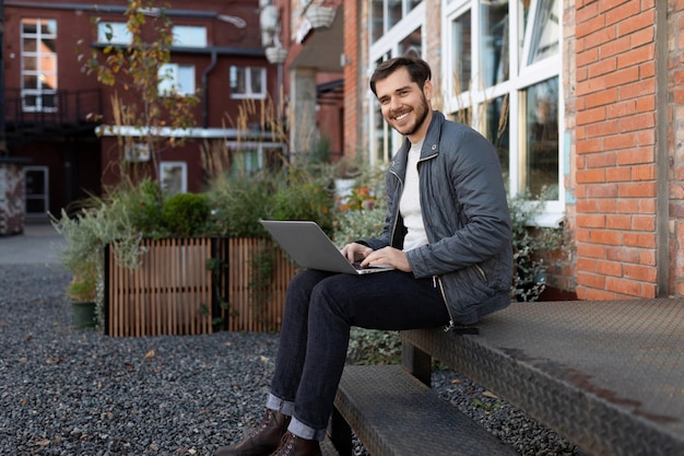 Il libero professionista europeo trasmette mentre è seduto con un laptop per strada