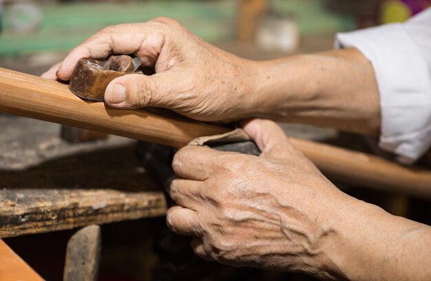 Il maestro adulto restaura vecchi strumenti musicali. intaglio del legno
