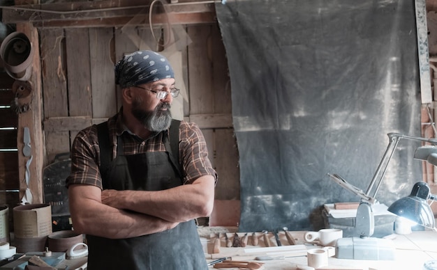 Il maestro del cucchiaio nella sua bottega con prodotti e strumenti in legno. Foto di alta qualità